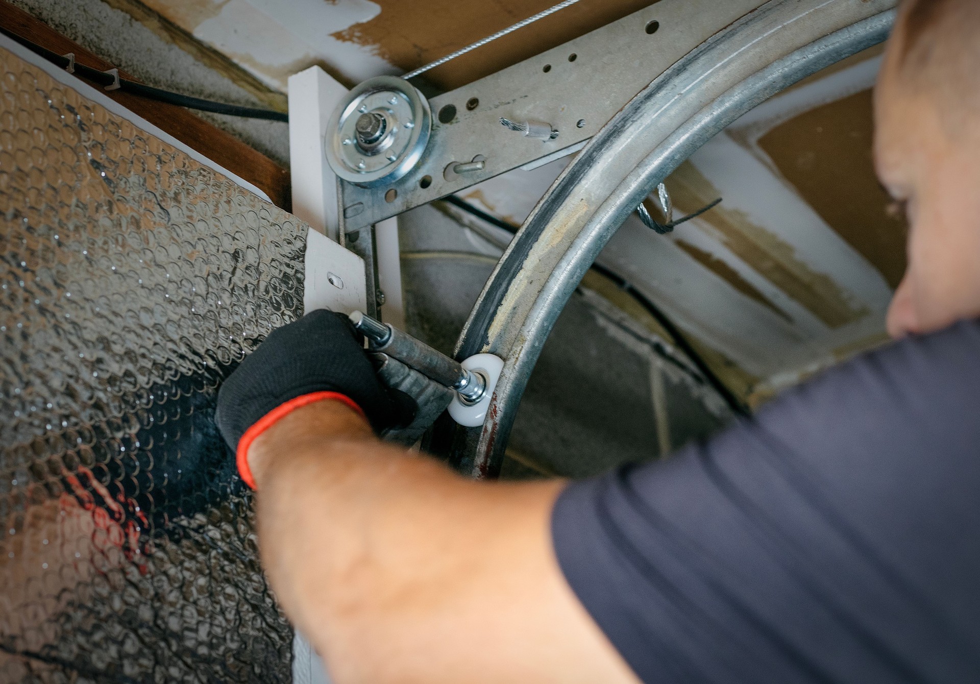 Man repairing garage door from inside